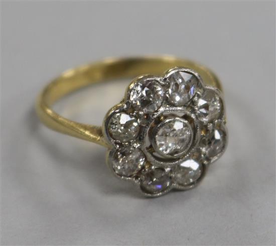An 18ct gold and nine stone diamond cluster ring, size L.